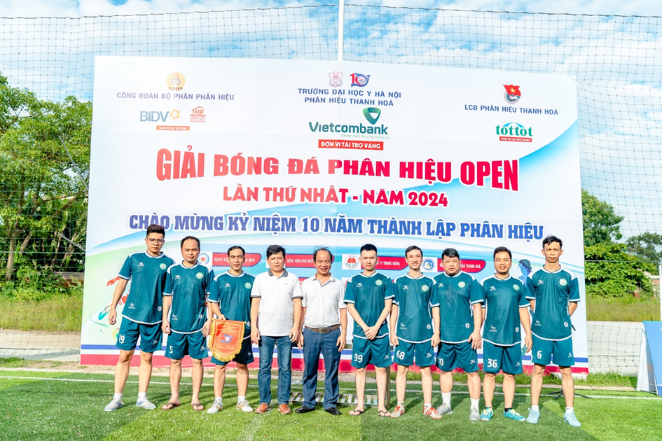 A group of men in uniform standing in front of a banner

Description automatically generated